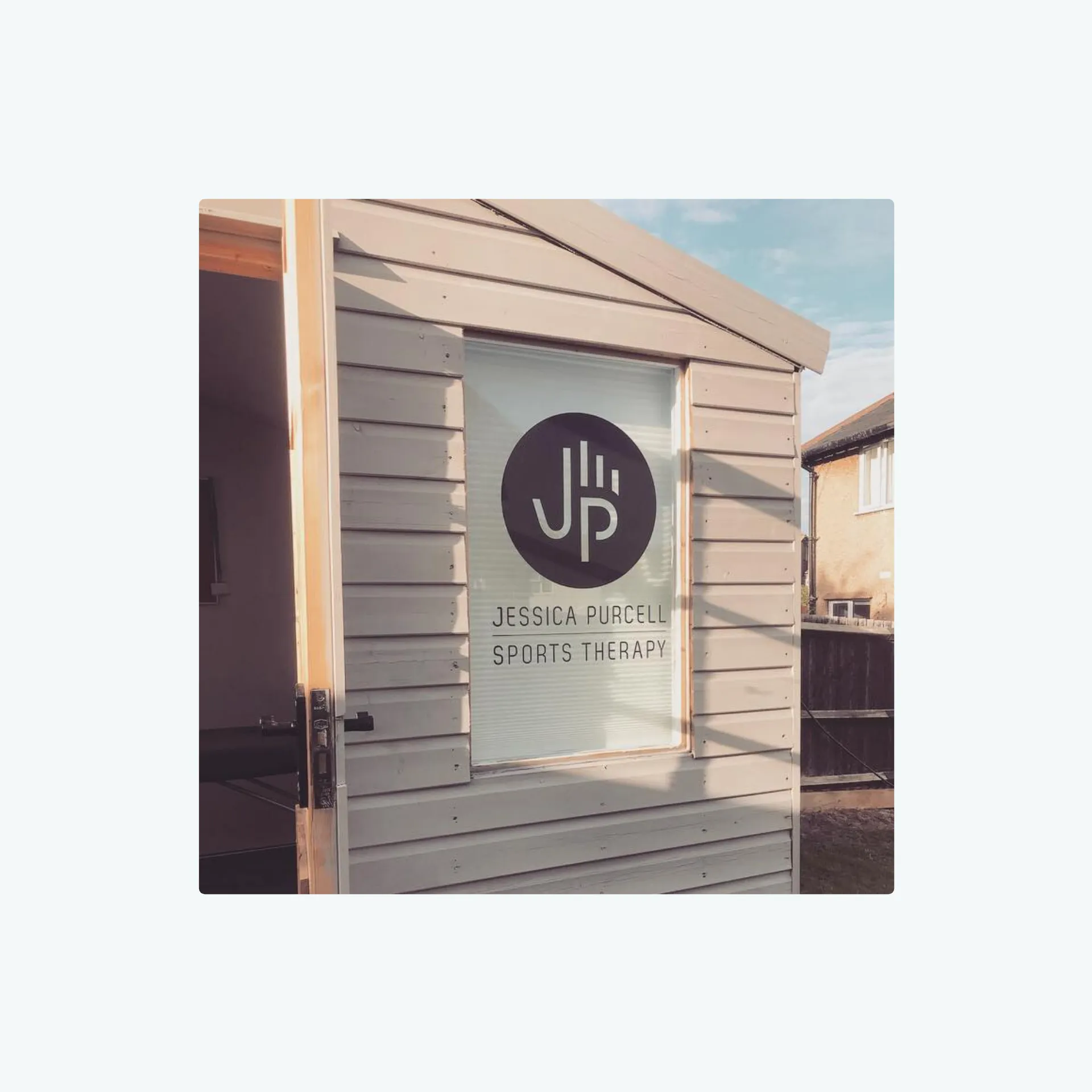 Black Jessica Purcell Sports Therapy abstract hand logo shown on the window of her treatment room.