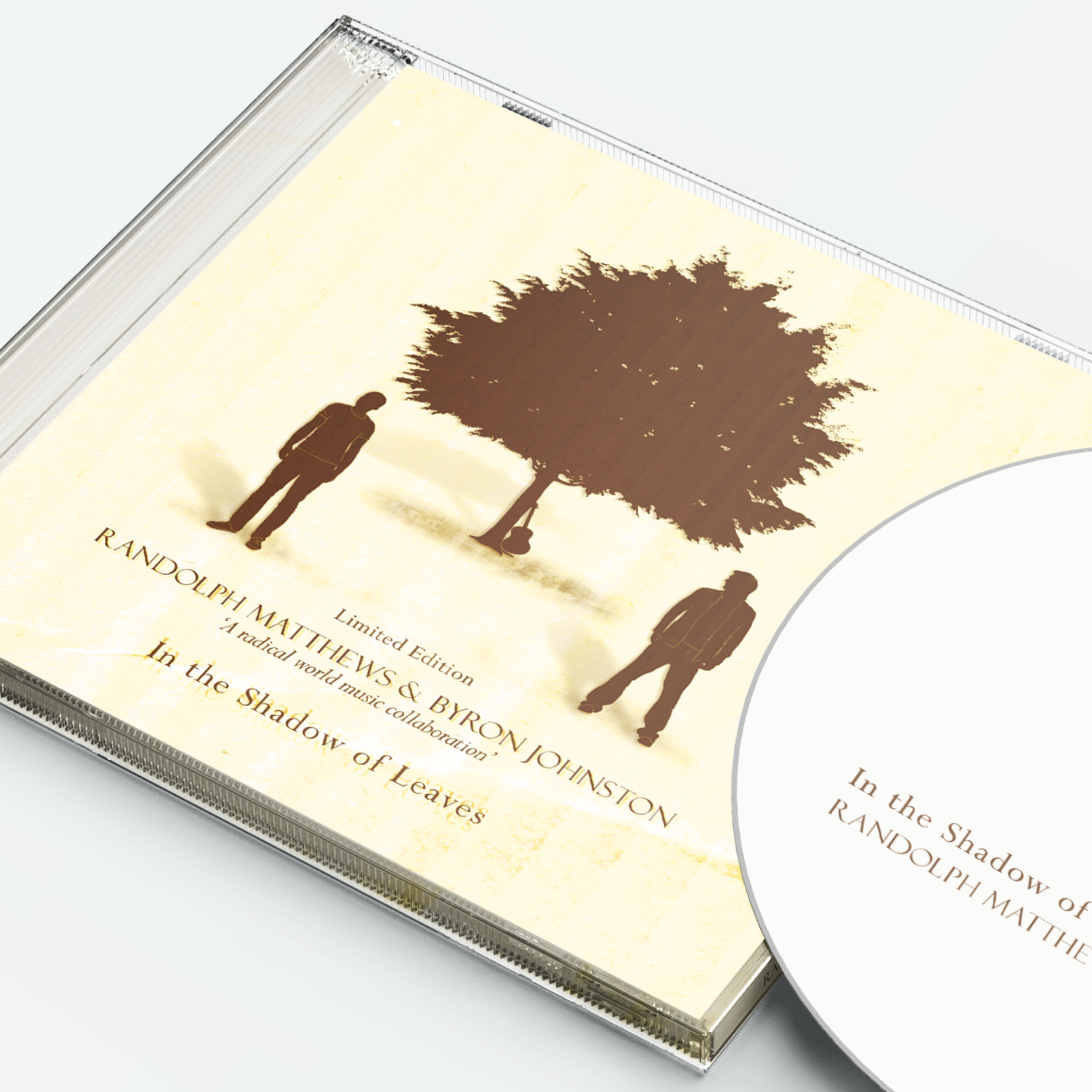 CD case featuring the cover art for In the Shadow of Leaves, showing two silhouetted male figures by a tree with an acoustic guitar leaning against the trunk, in brown and earthy tones. Part of the CD is also visible.