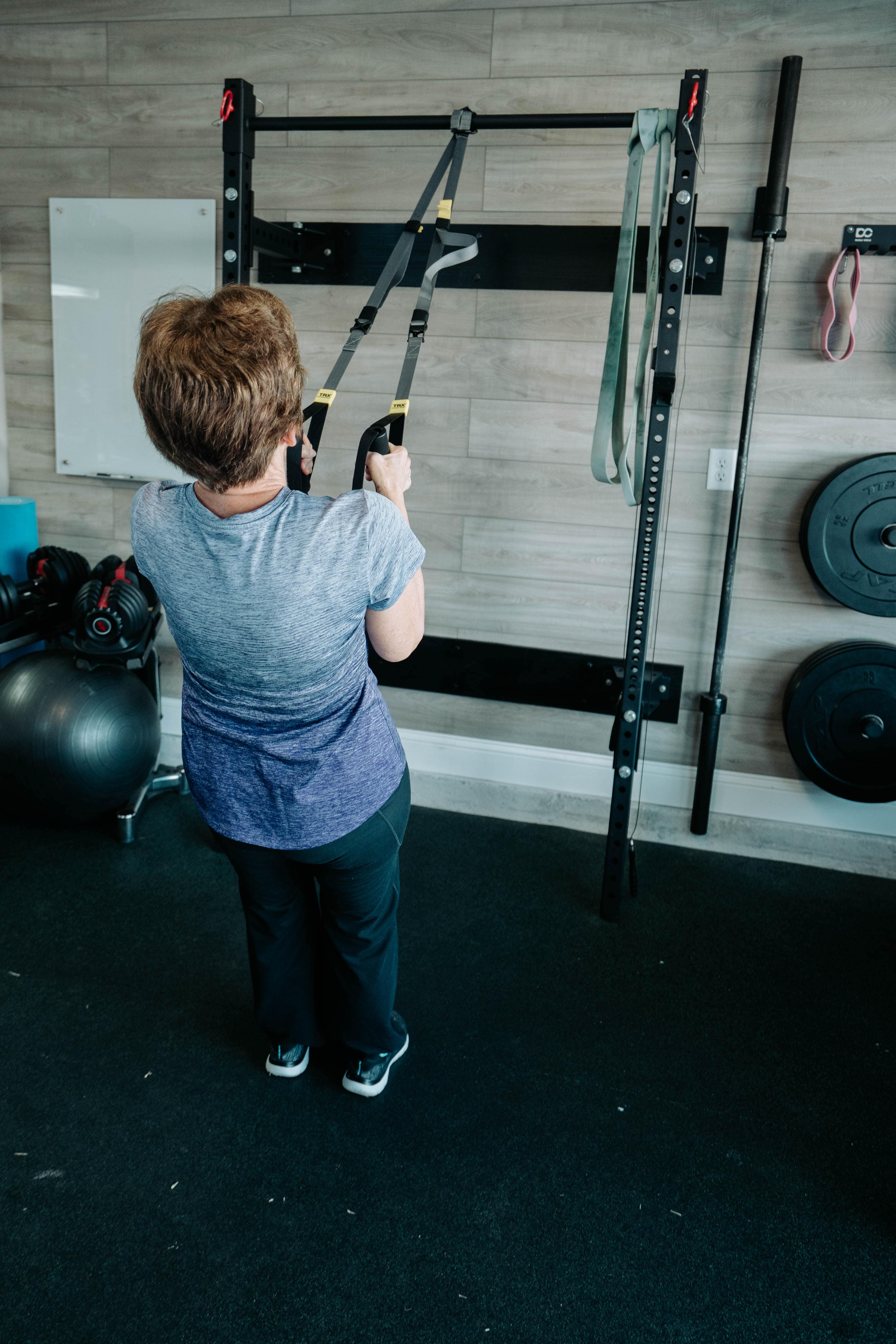 Elderly woman doing suspension trainer standing rows