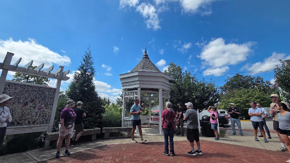 Jerry Finn talks about the history of the church in the rear garden. The roof of this gazebo was once part of the church before the steeple was restored.