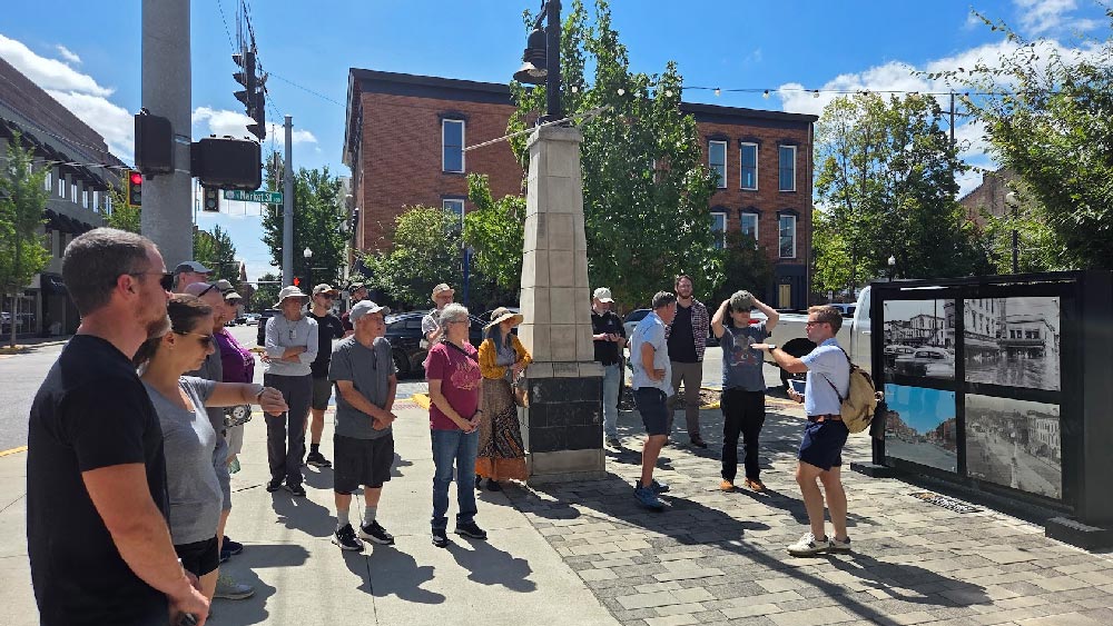 Jacob Resch discussing the history of the the former Woolworths and showing historic pictures on his tablet