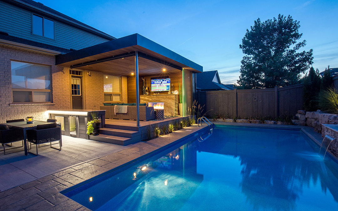 Backyard pool and an open and covered patio with a fireplace and sofa.