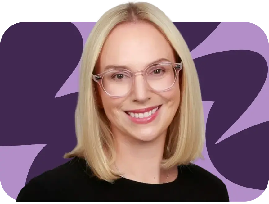 Smiling woman with straight blonde hair wearing clear eyeglasses and a black top, with a purple abstract background.