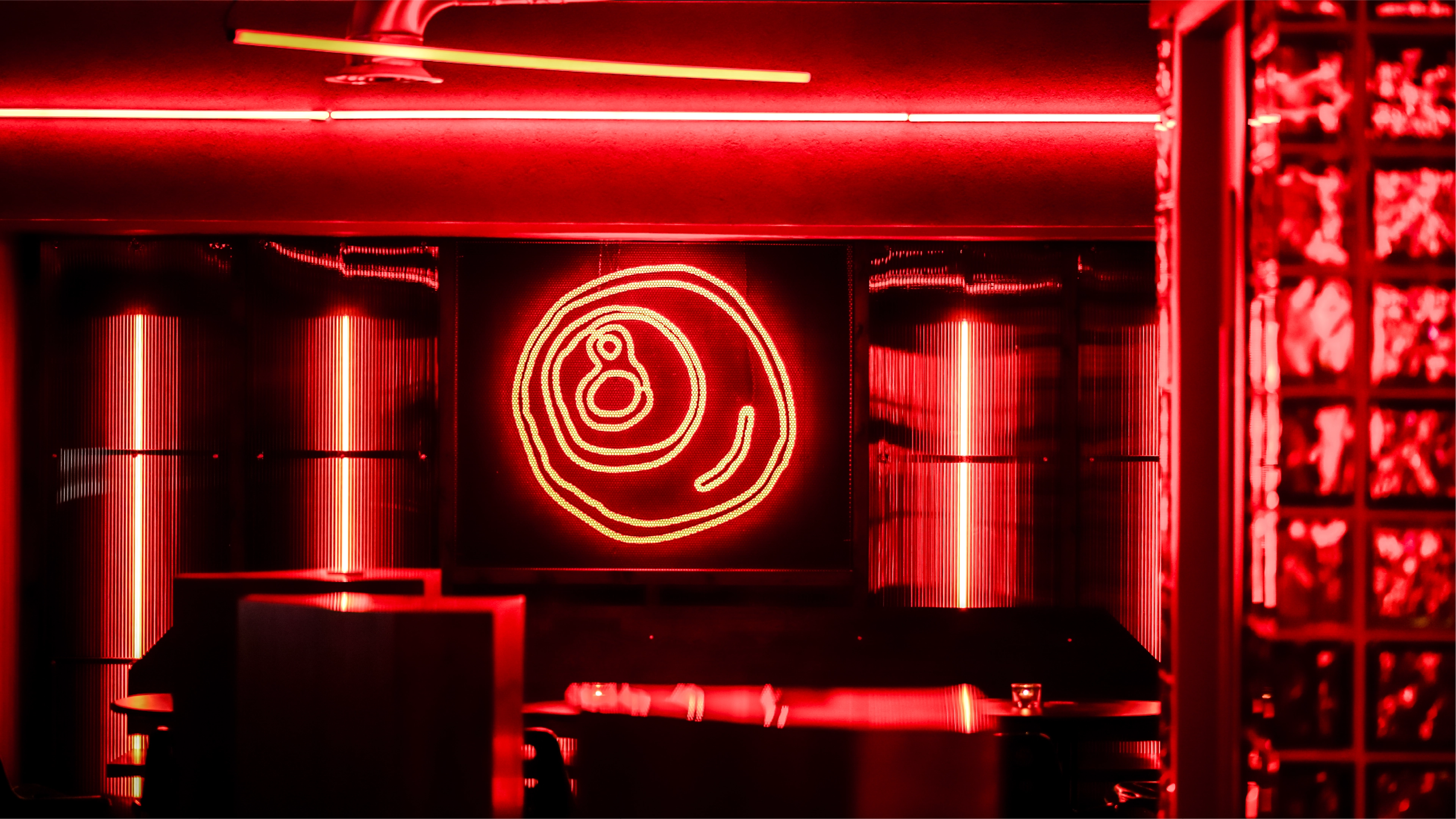 

A red star shaped neon light inside the Salon Madre venue created using one of the ink drawn icons from the Salon Madre brand identity by Sanna Studio