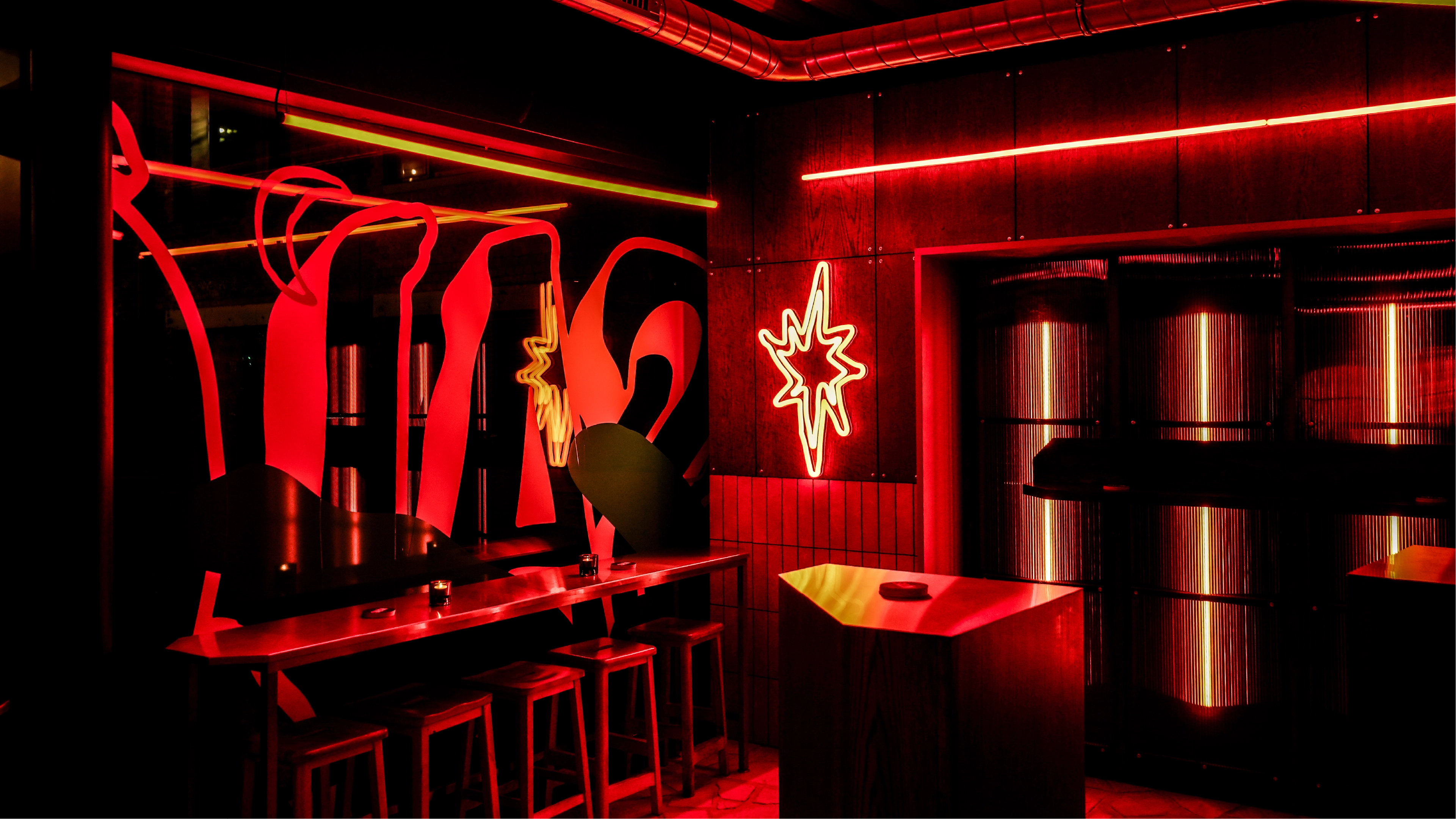 A red star shaped neon light inside the Salon Madre venue created using one of the ink drawn icons from the Salon Madre brand identity by Sanna Studio