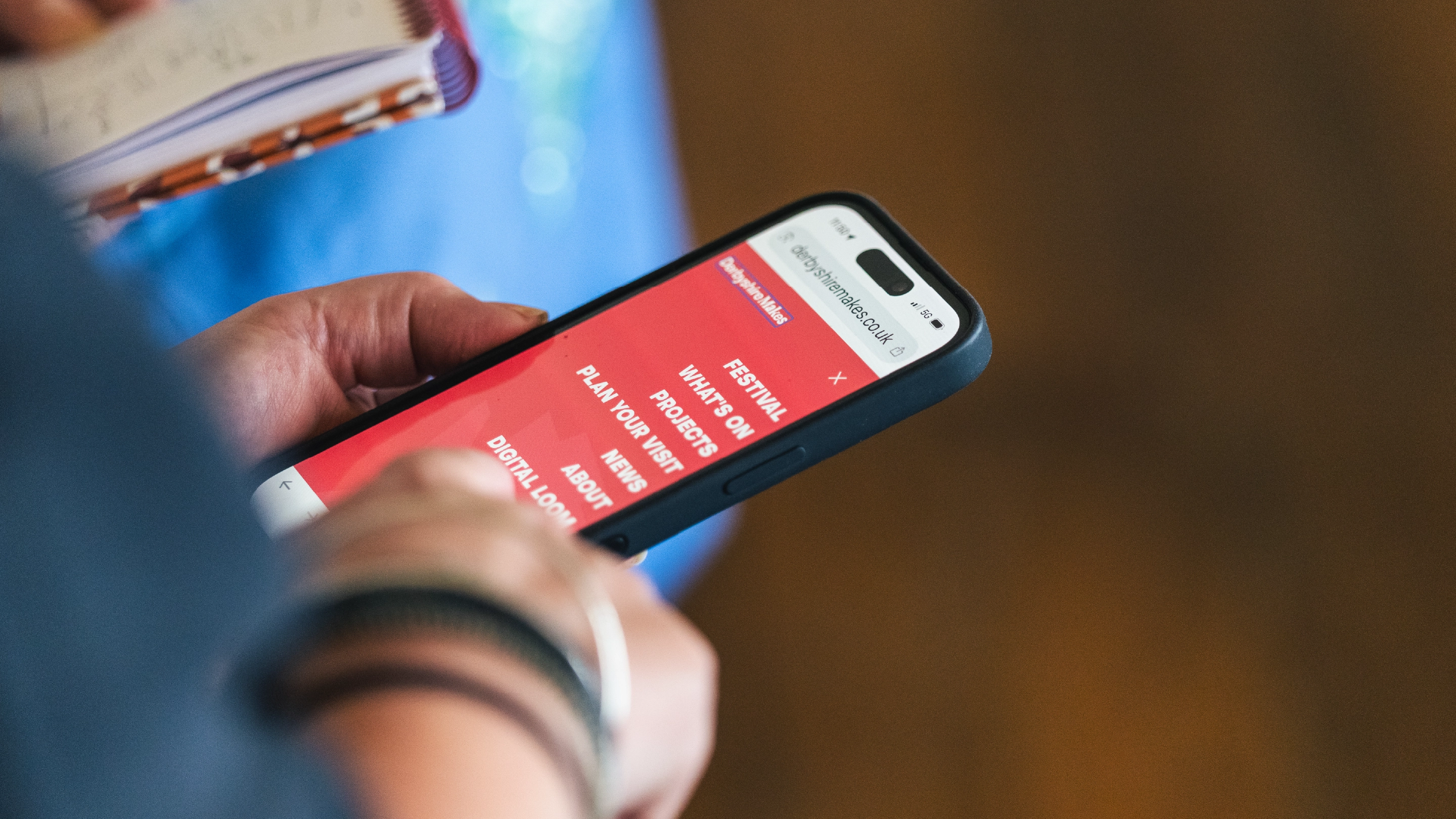 Photograph of someone using the mobile website for Derbyshire Makes Festival programme.