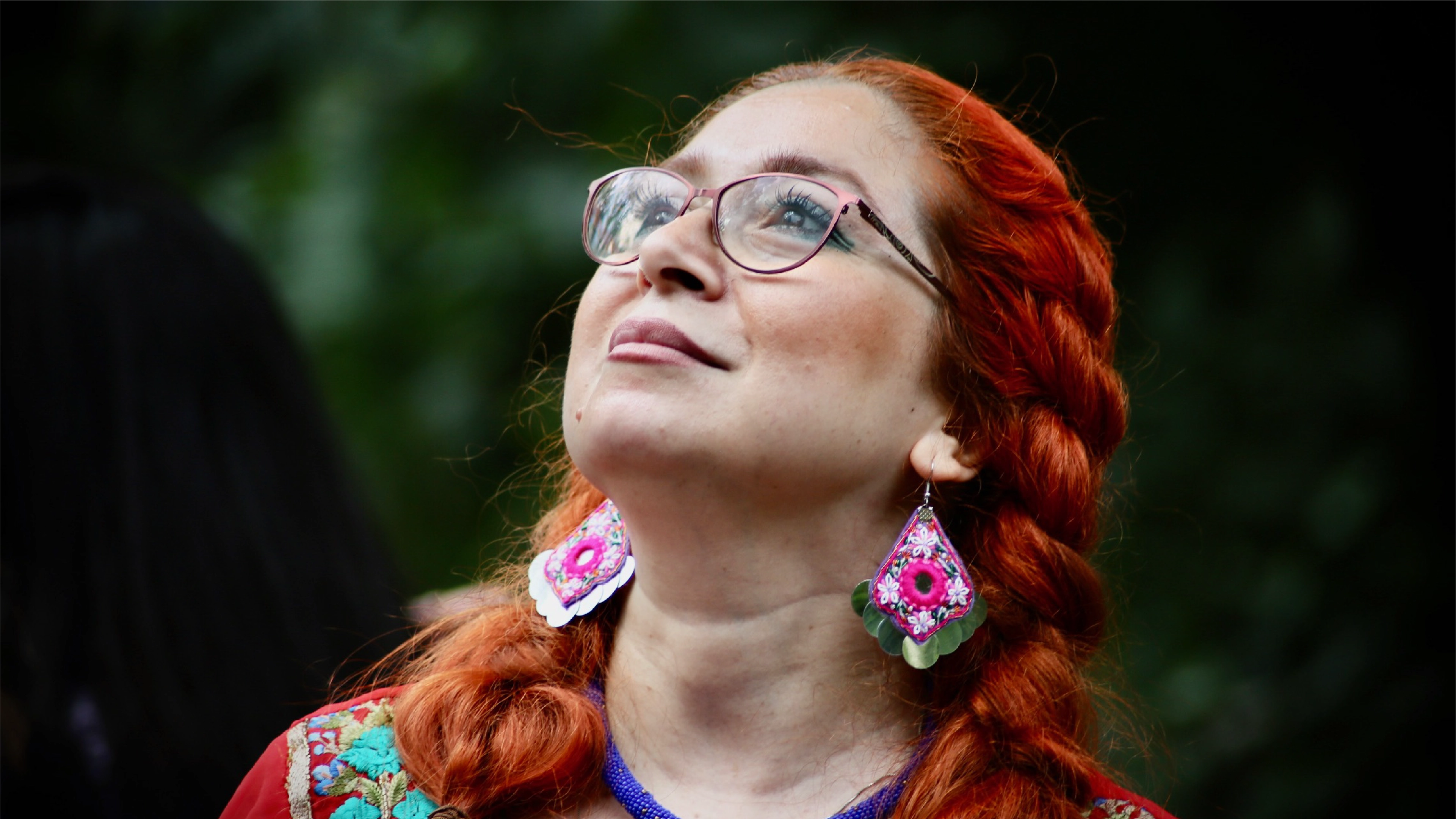 Photograph of woman with red hair and earrings looking up with the Result CIC logo
