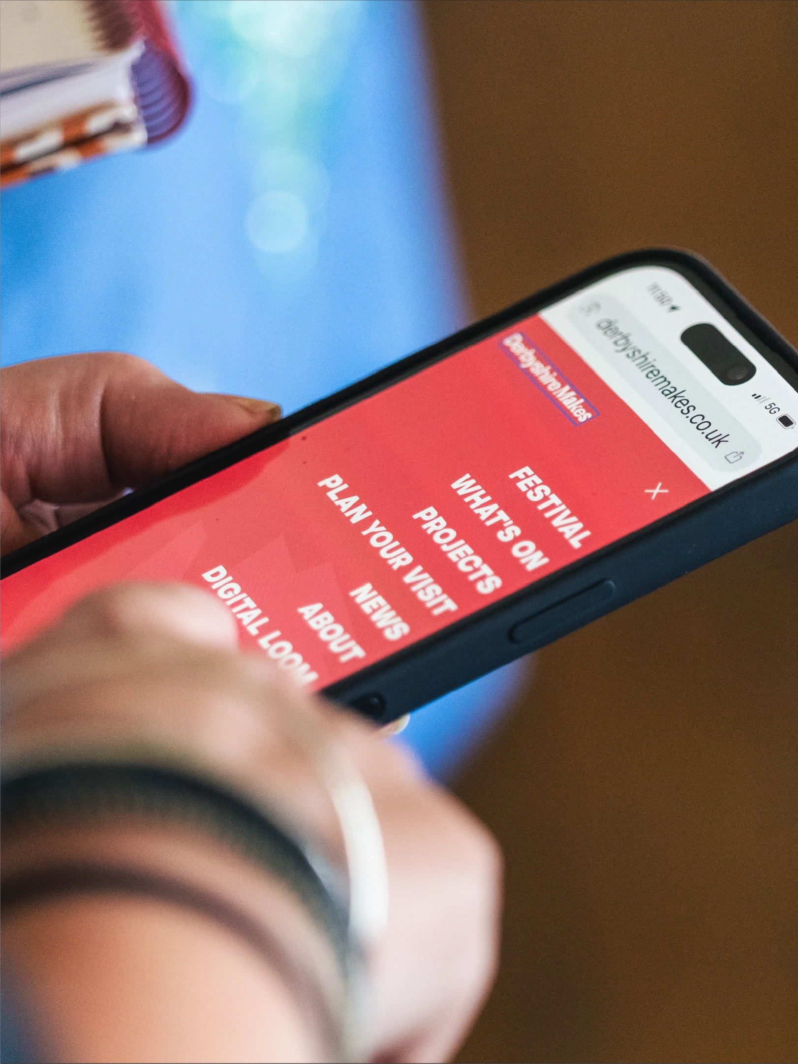 Photograph of someone using the mobile website for Derbyshire Makes Festival programme.