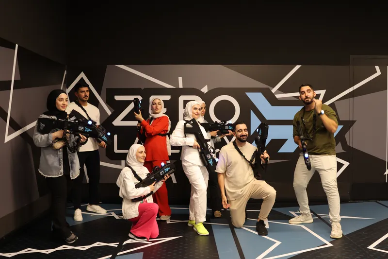 A group of players posing at the Zero Latency wall in Abu Dhabi