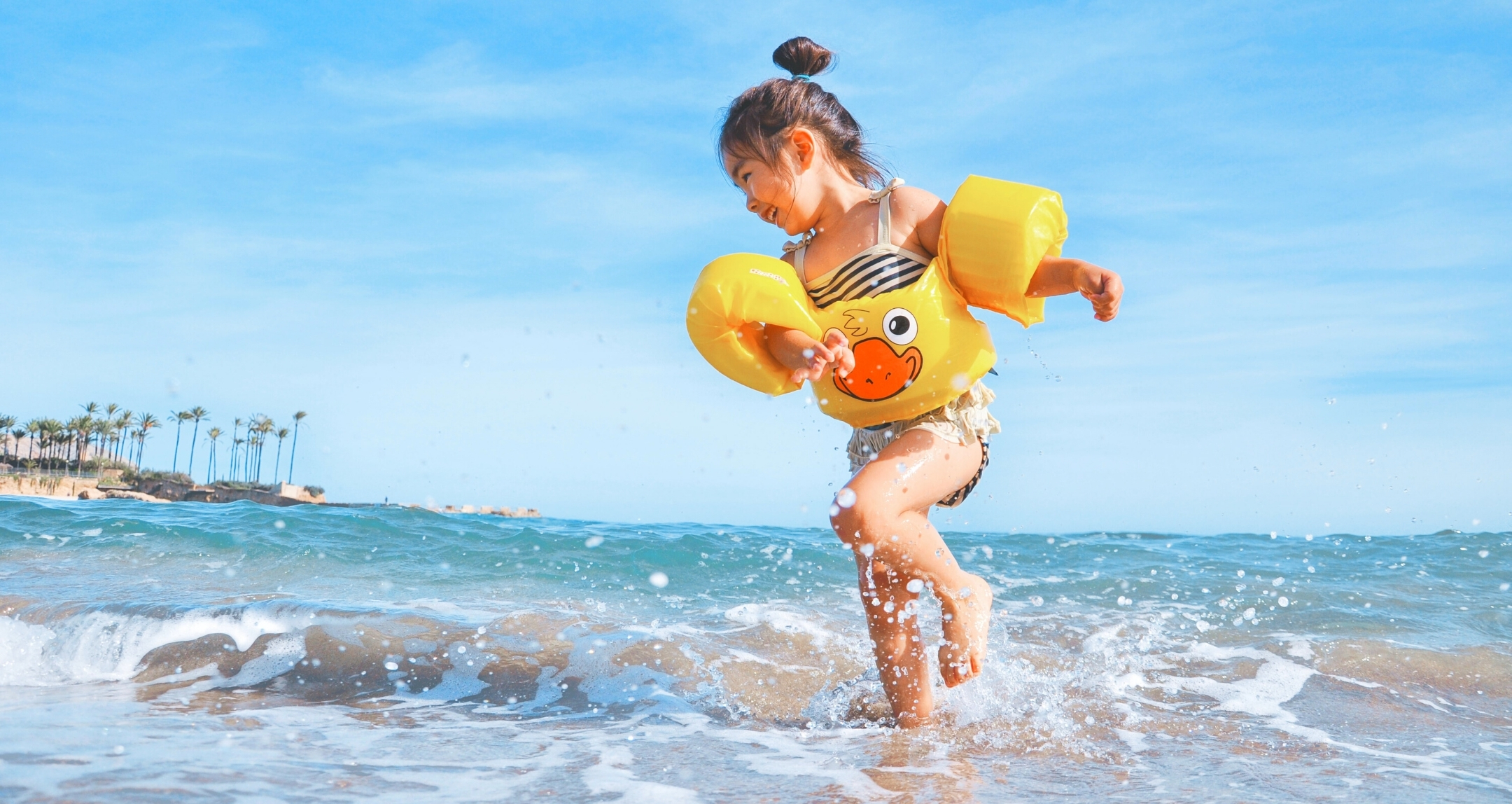 Little Asian girl playing at the beach.