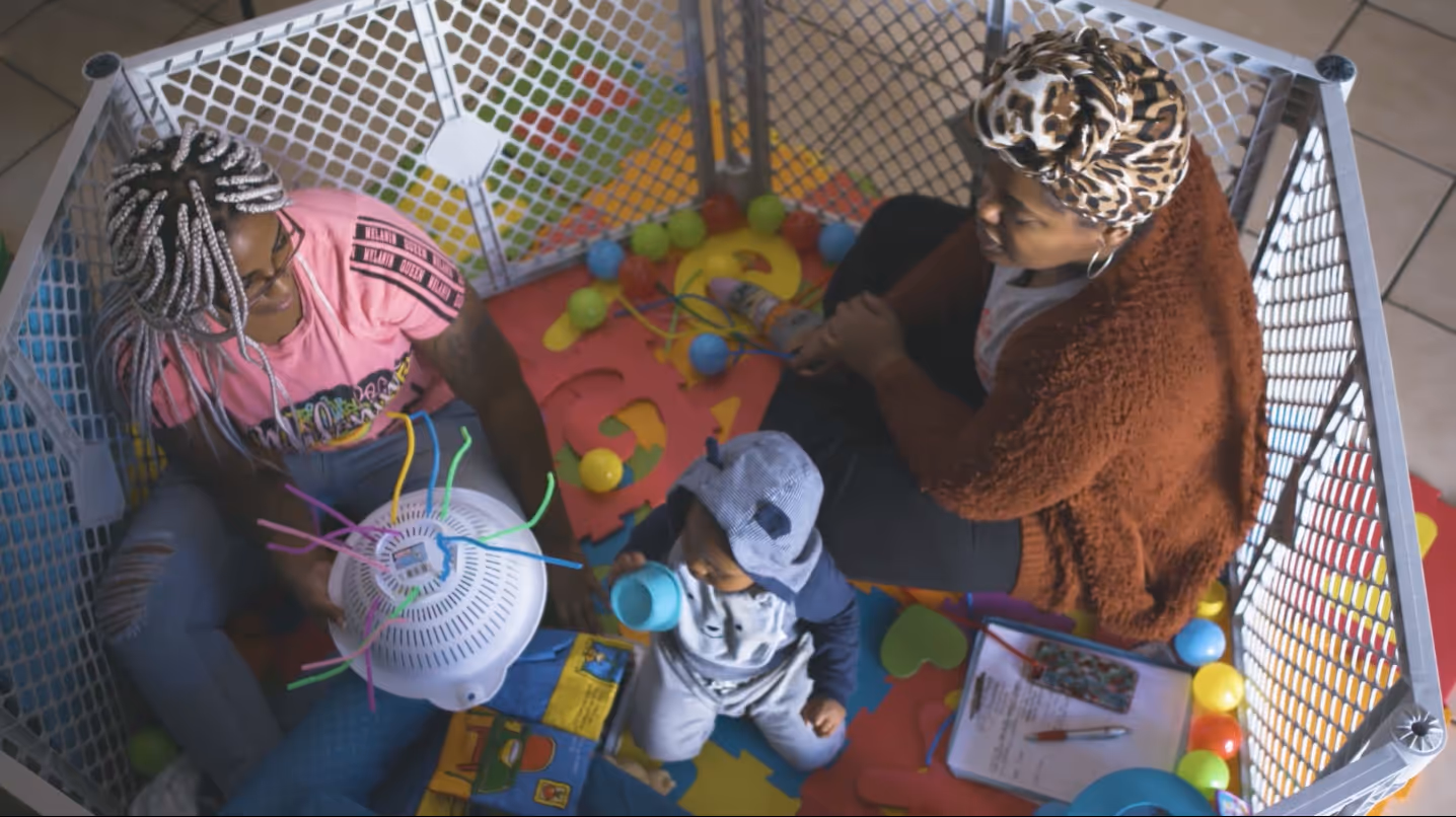 Nurse interacting with child in playpen during NNCC commercial filmed by Camos Media.