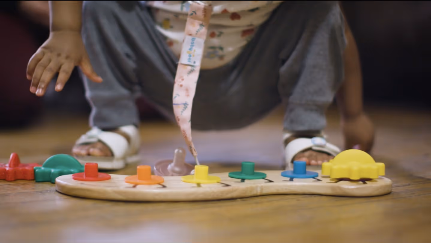 Baby playing with toy puzzle during NNCC commercial filmed by Camos Media.
