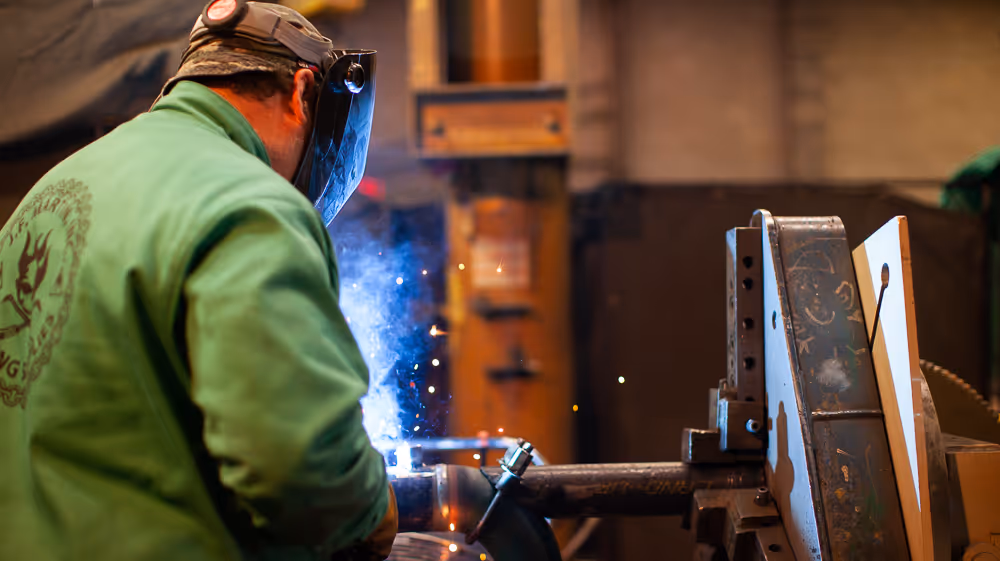 Welder working in shop featured in commercial for Tracey Mechanical filmed by Camos Media. 