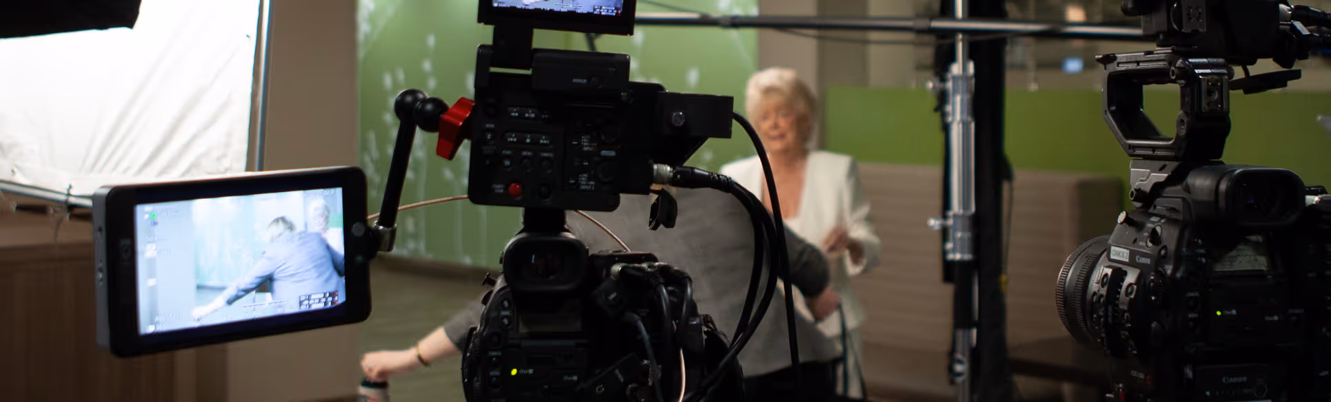 Behind-the-scenes of a commercial interview on green backdrop, captured by Camos Media.