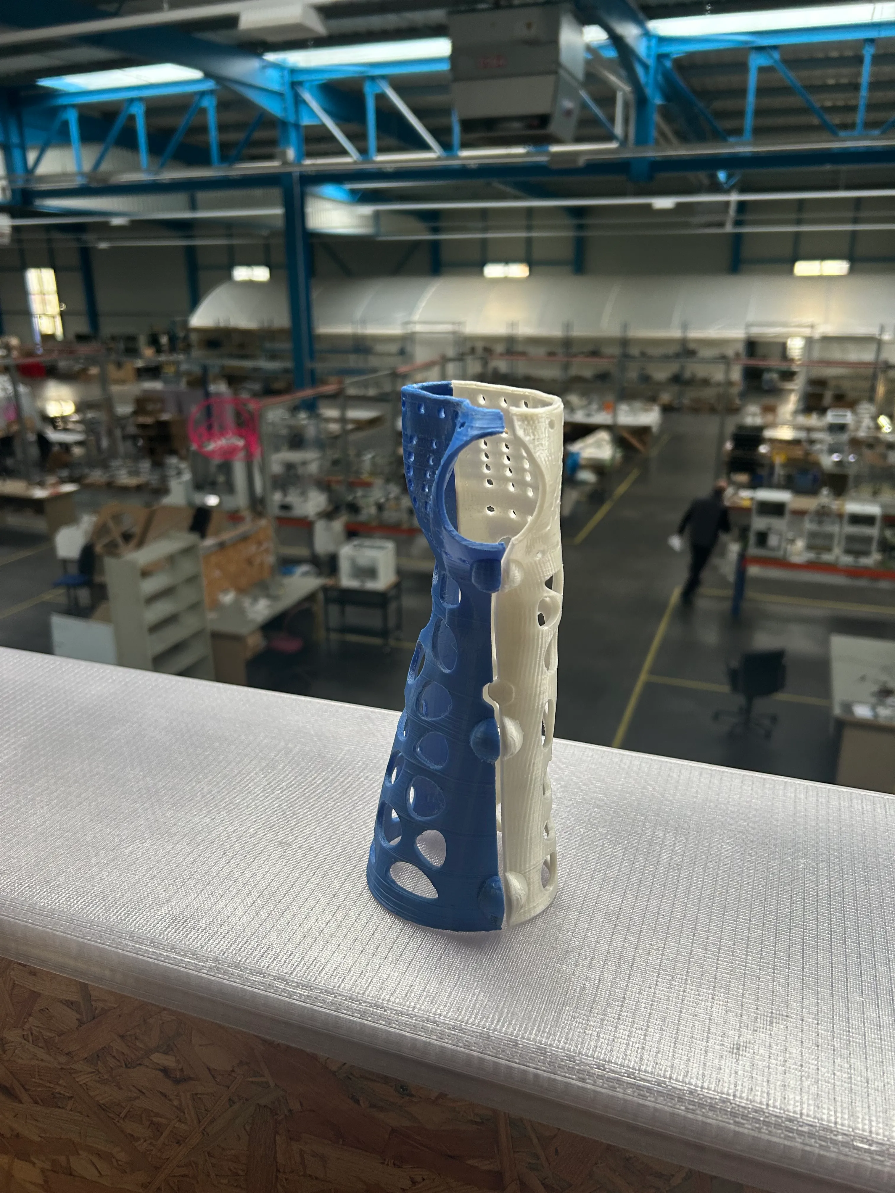 Imprimante 3D Ultimaker vide sur une table en bois avec une fenêtre et une voiture bleue en arrière-plan.