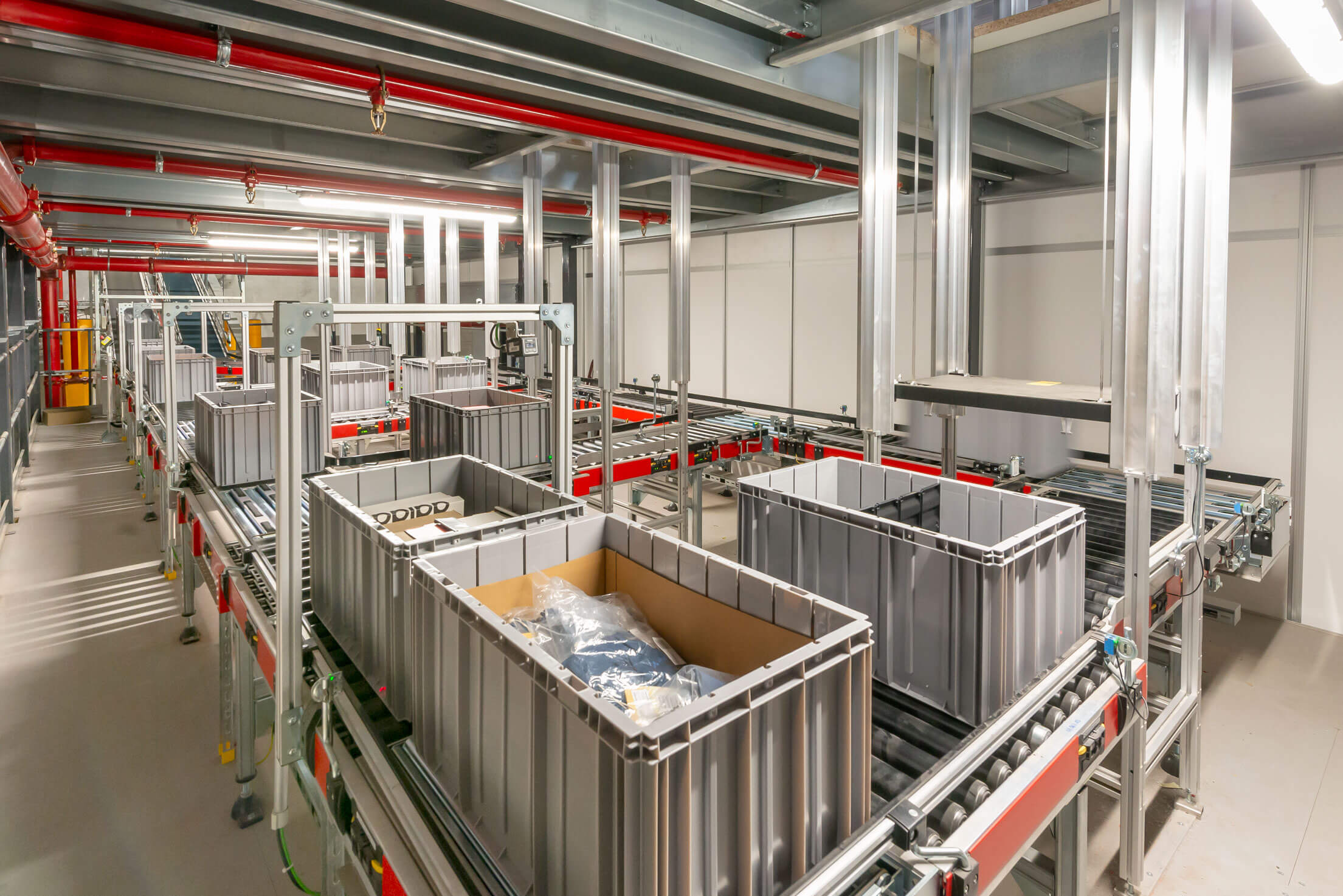 Four transfer cells with conveyor technology are integrated for the goods storage processes. They connect the AutoStore system with the repacking stations in the incoming goods area.