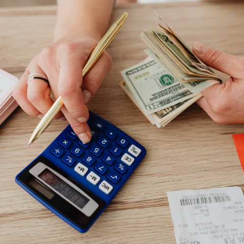 someone doing calculations with cash in hand
