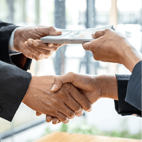 two people shaking hands and handing over money