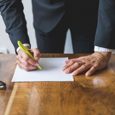 Borrower and cosigner signing a loan agreement with a bank manager