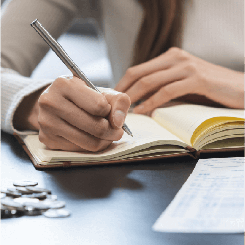 Woman planning a monthly budget in a notebook