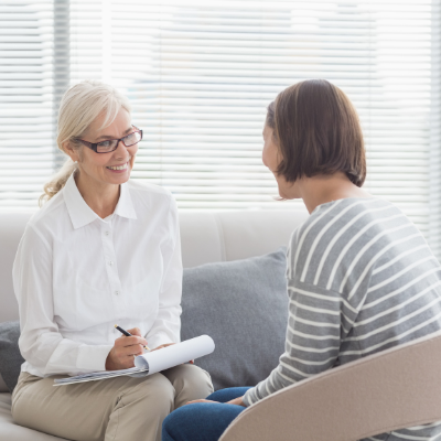 Therapist taking notes while speaking with a patient