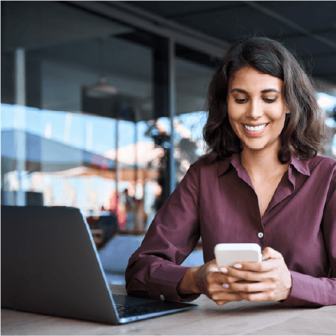 woman working with a phone and laptop