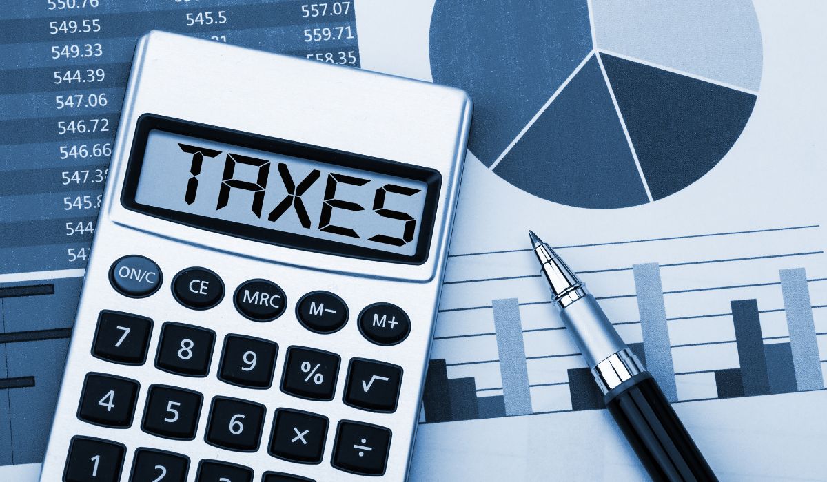 graphs and a calculator with the word Taxes written across the screen