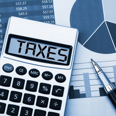 graphs and a calculator with the word Taxes written across the screen