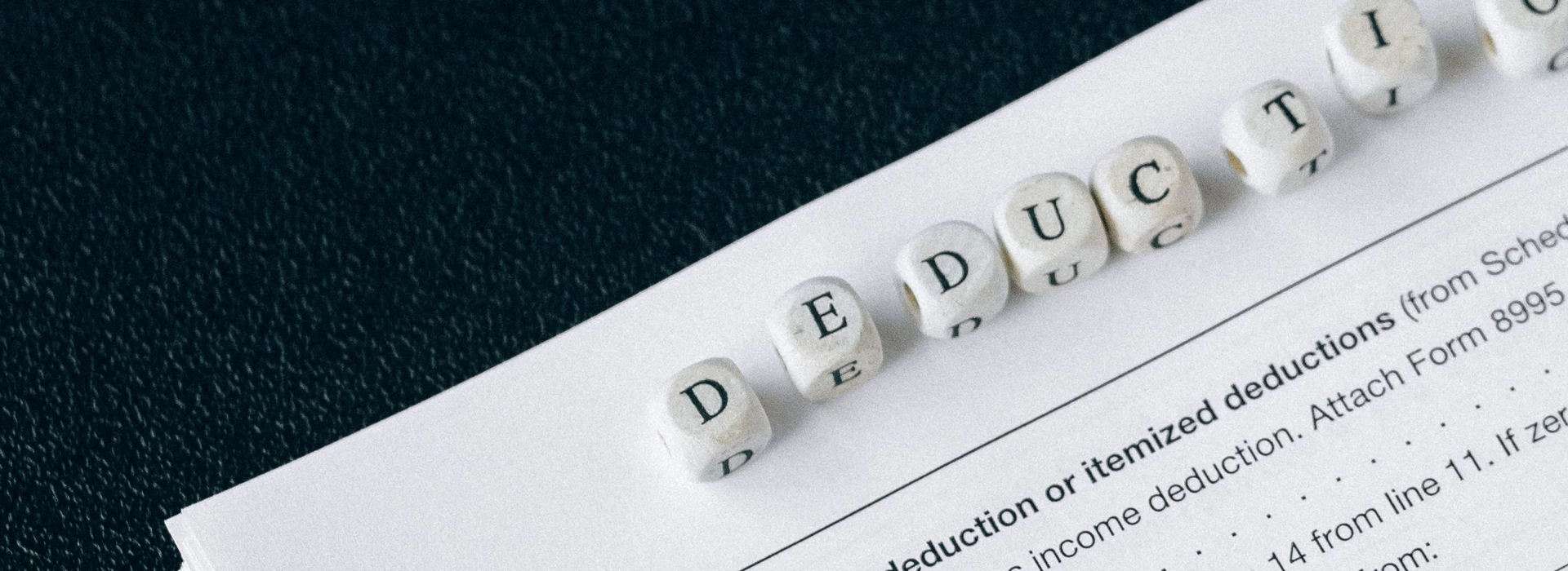 Tax documents labeled deductions beside a calculator