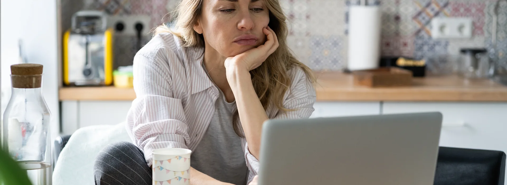 Woman reviewing job listings on a laptop at home