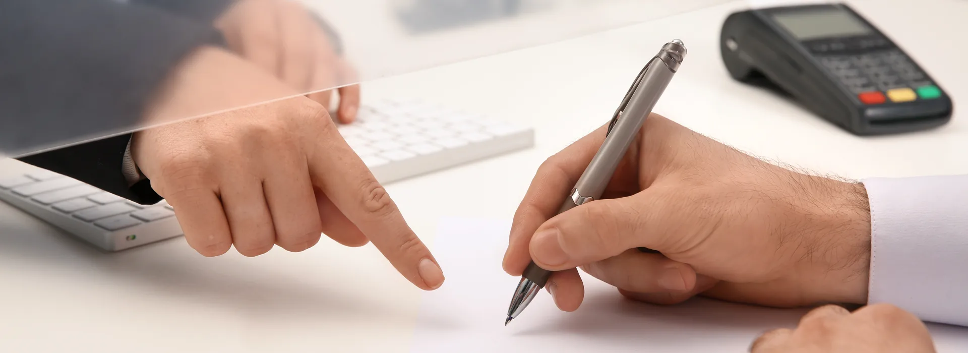 Customer completing a form at a financial service counter