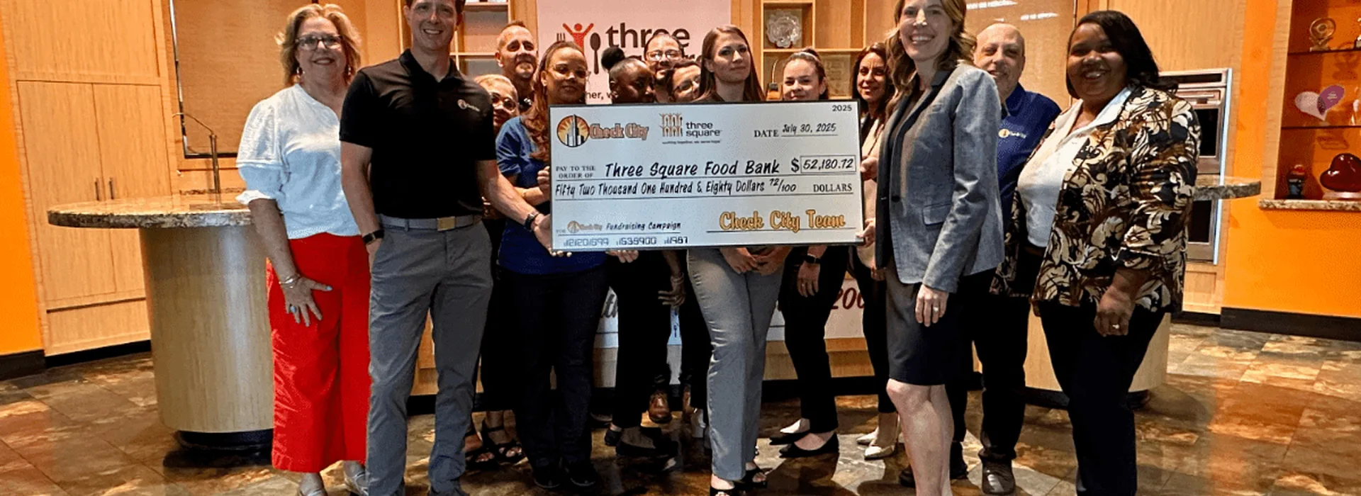 Check City representatives presenting a donation check to Three Square in 2025