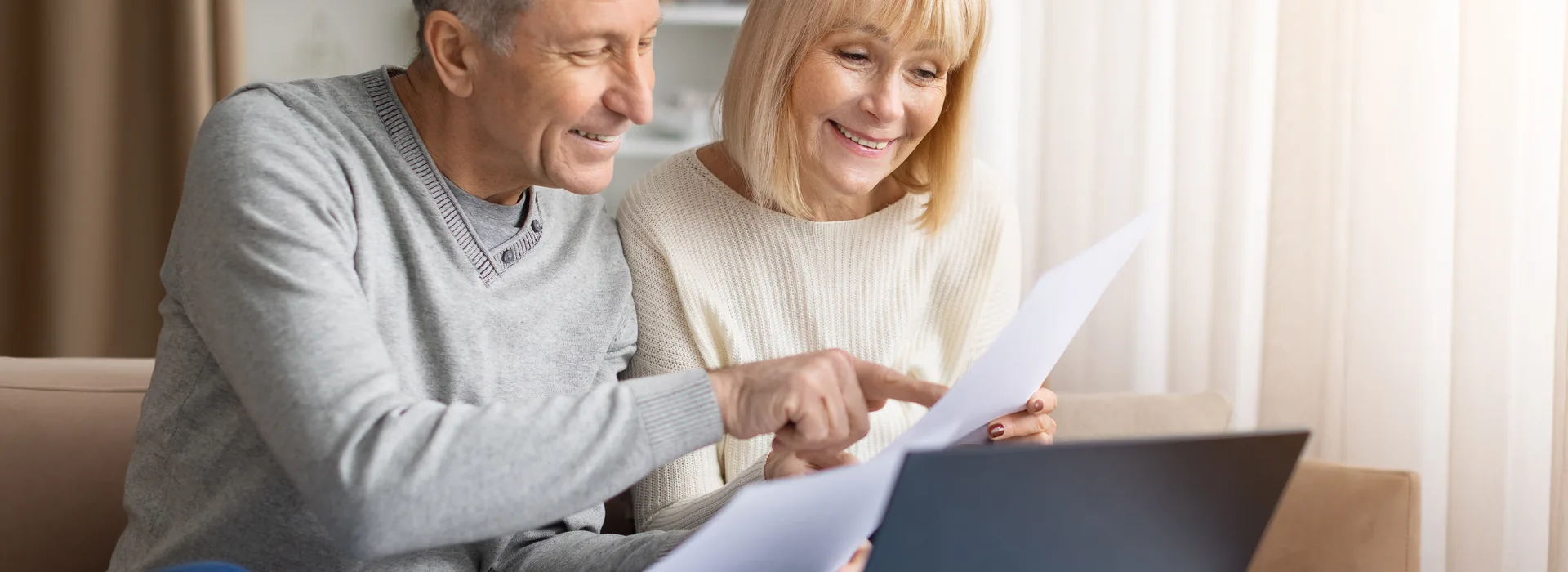 Couple comparing household tax documents on a laptop