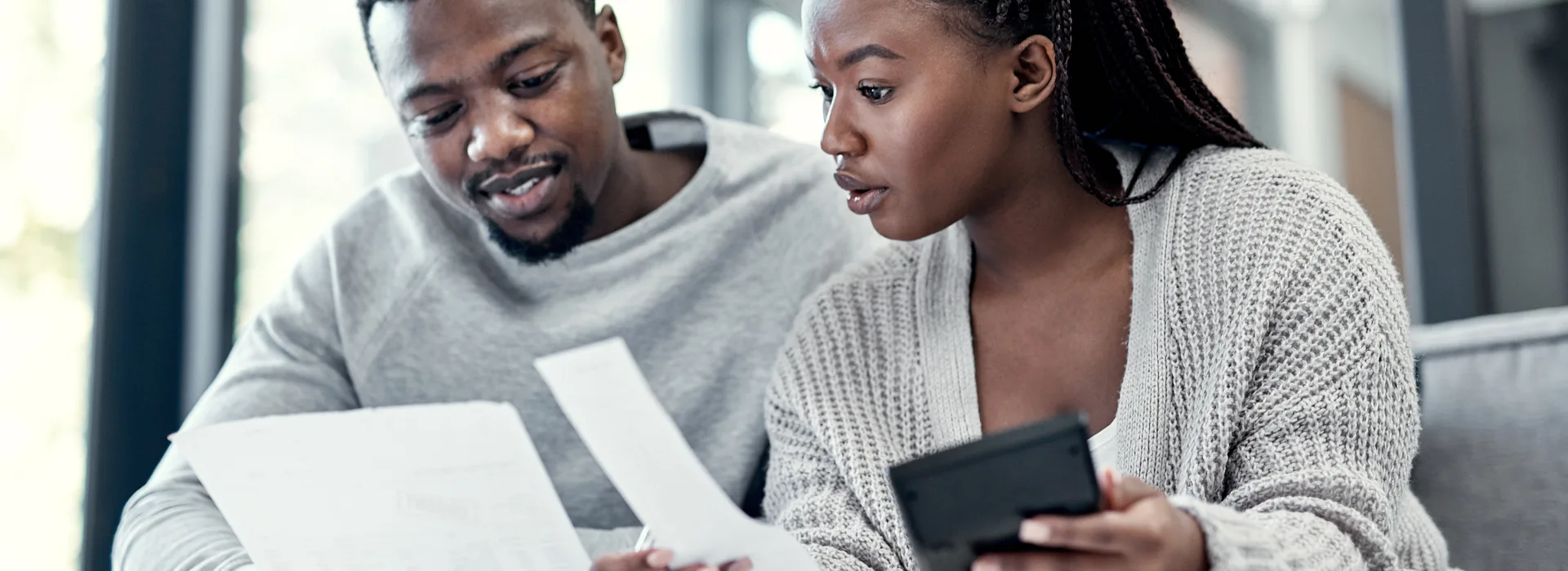 Couple reviewing financial paperwork and loan options at home