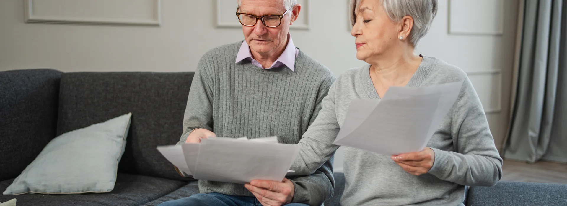 Retired couple reviewing bills and financial documents