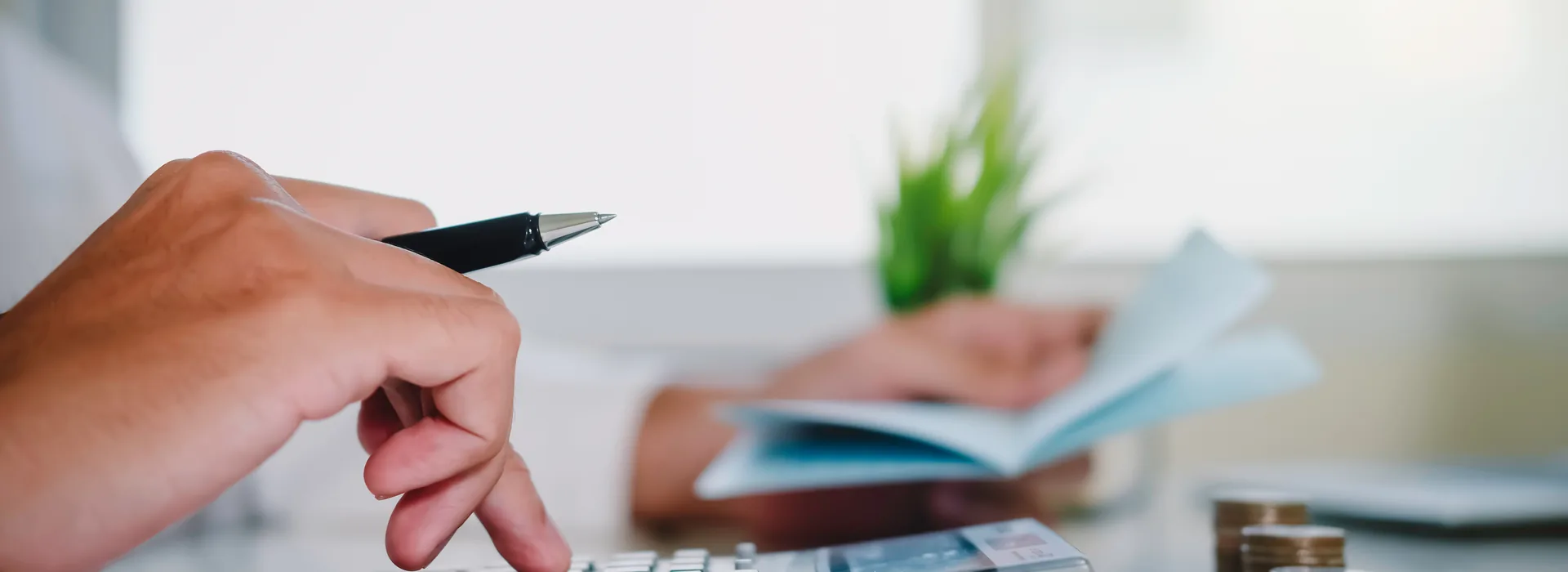Person using a calculator while reviewing installment loan paperwork