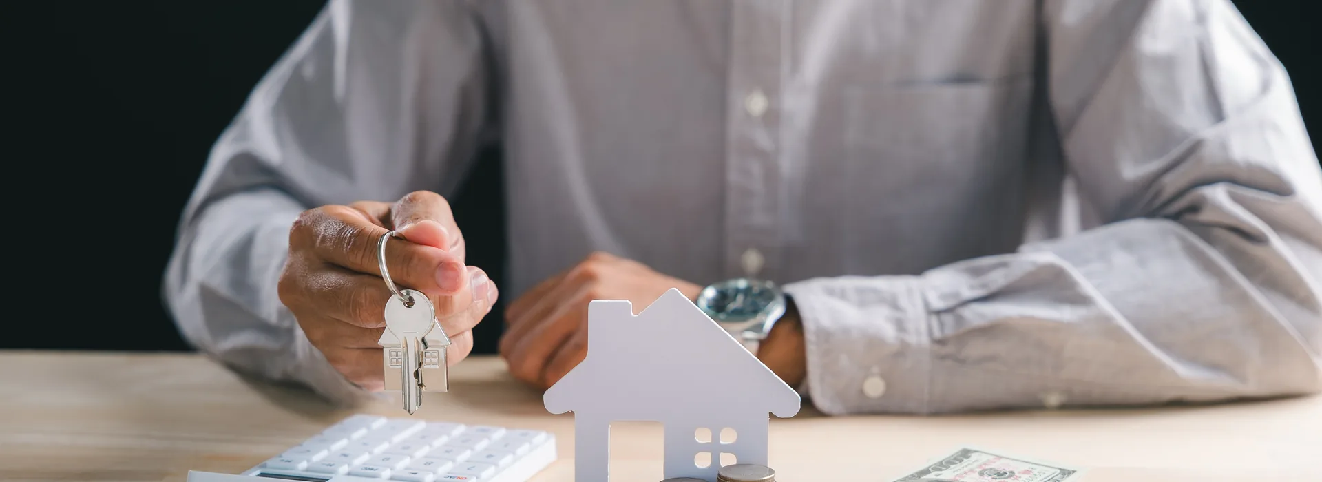 House keys, loan paperwork, and U.S. dollars on a desk