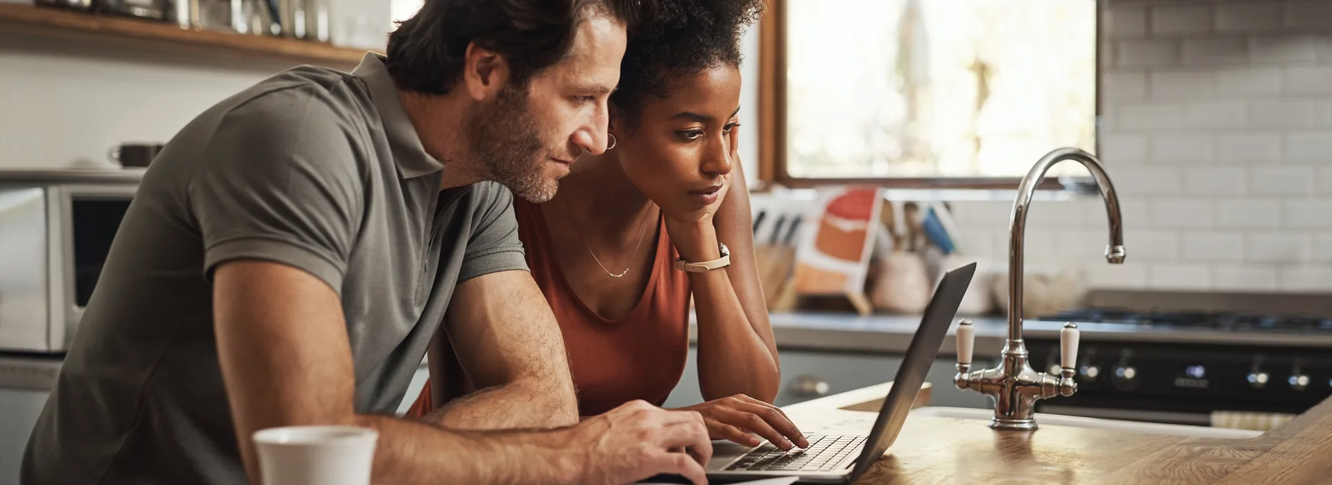 Couple comparing mortgage loan information on a laptop at home