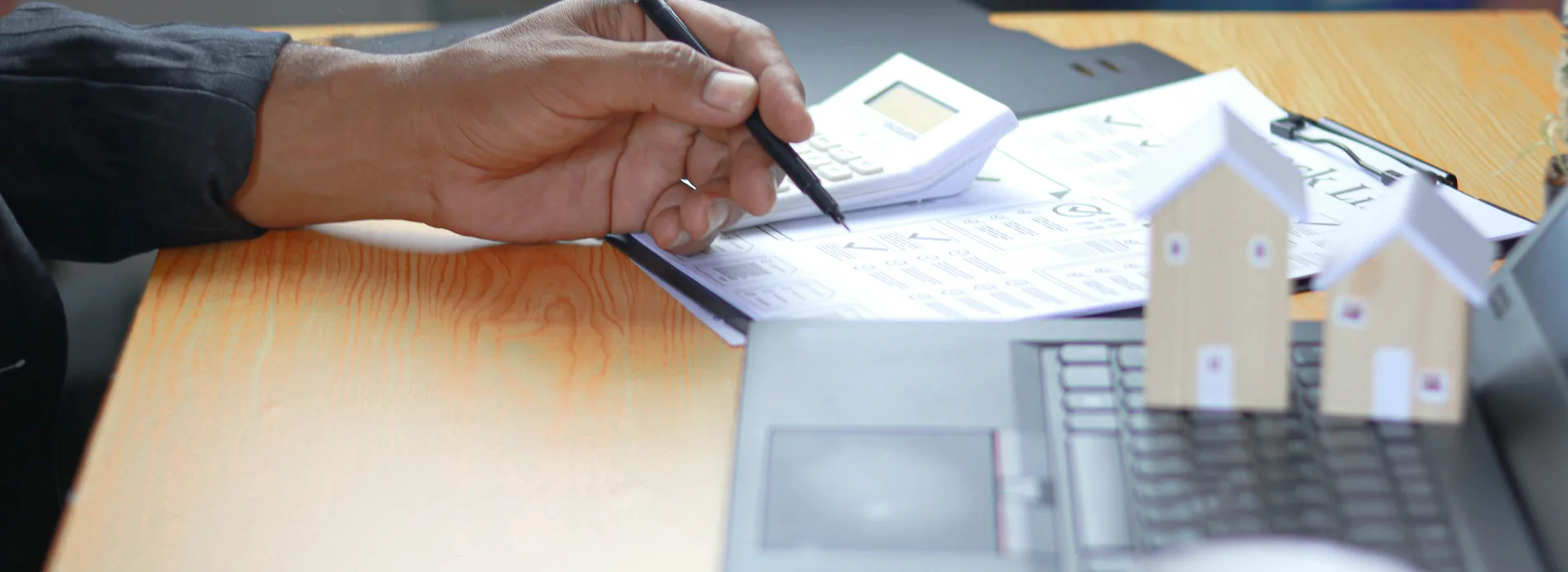 Financial professional reviewing personal loan documents beside house models