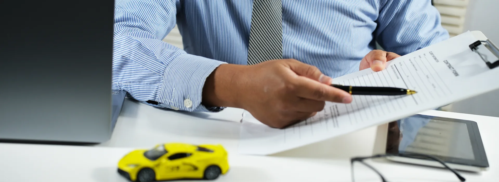 Customer reviewing car title paperwork with a salesperson