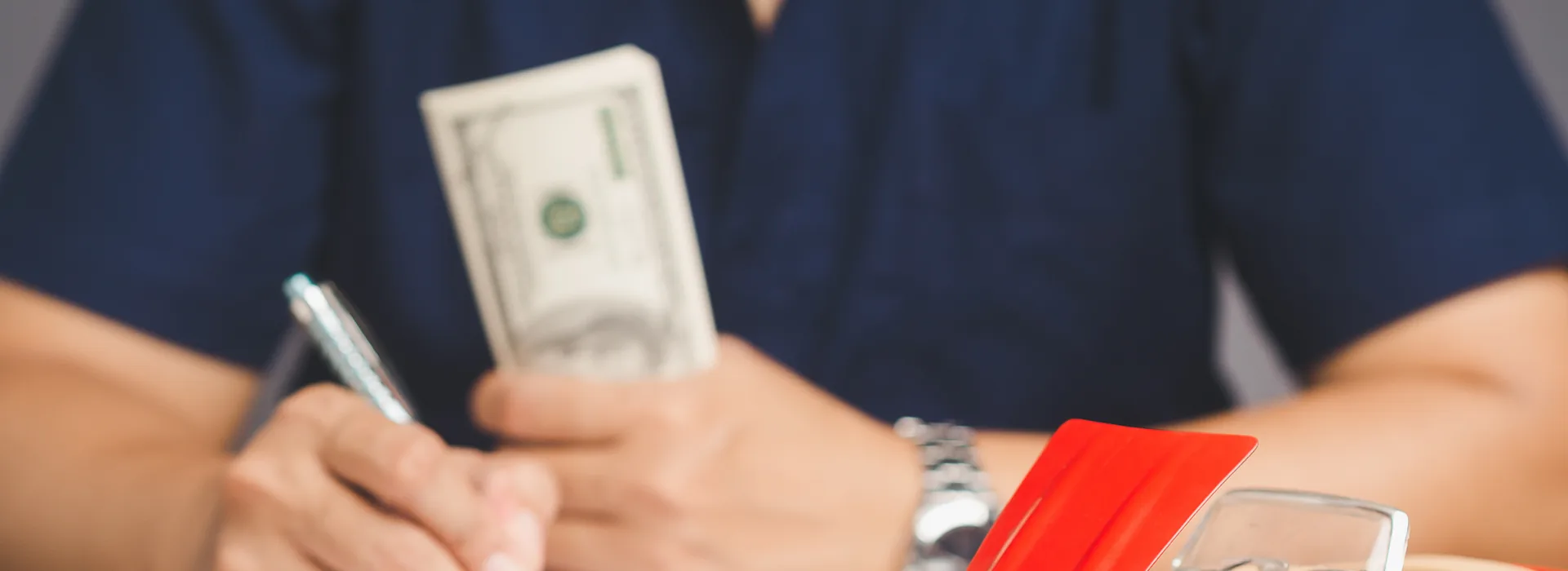 Borrower signing title loan paperwork while holding cash