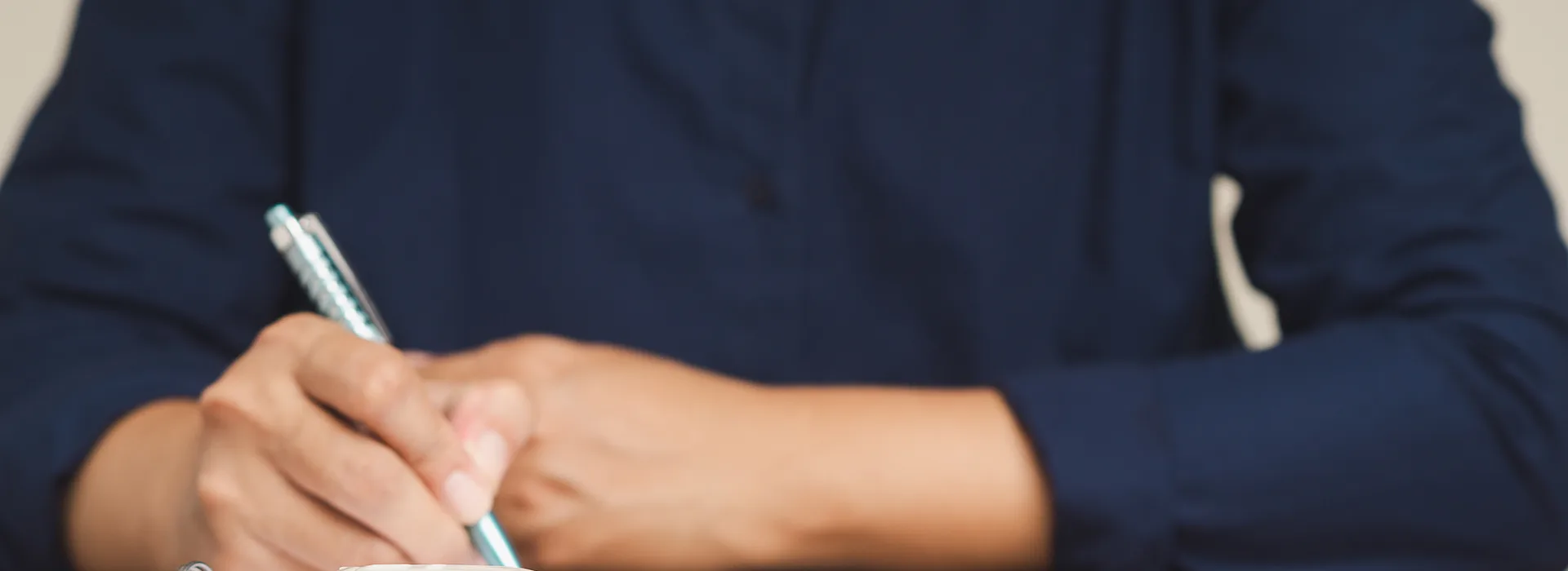 Borrower signing a collateral loan agreement beside car keys
