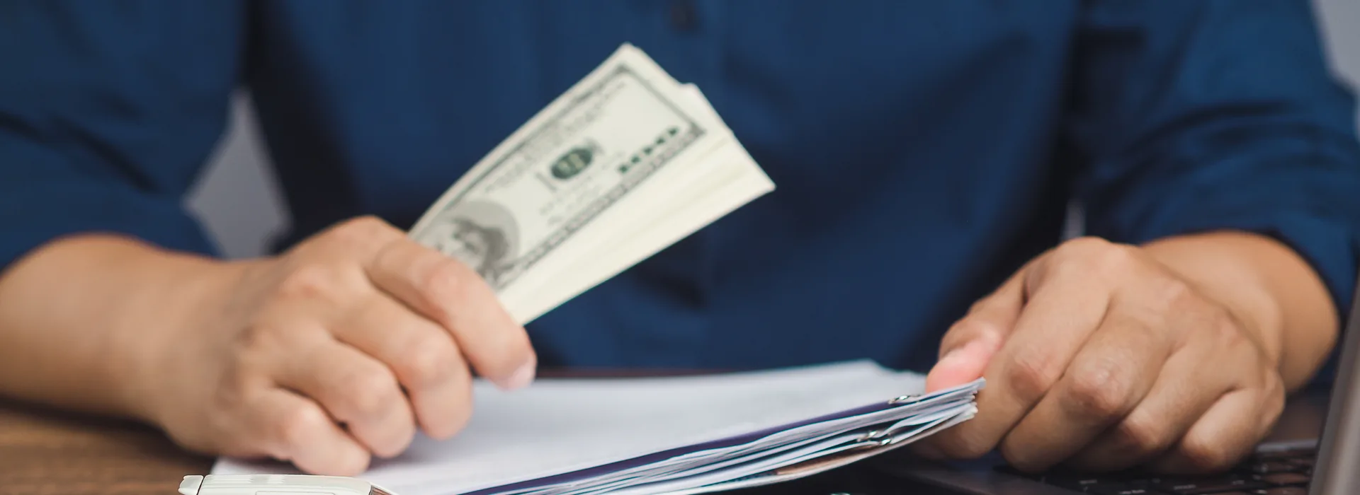Borrower holding cash while signing title loan paperwork
