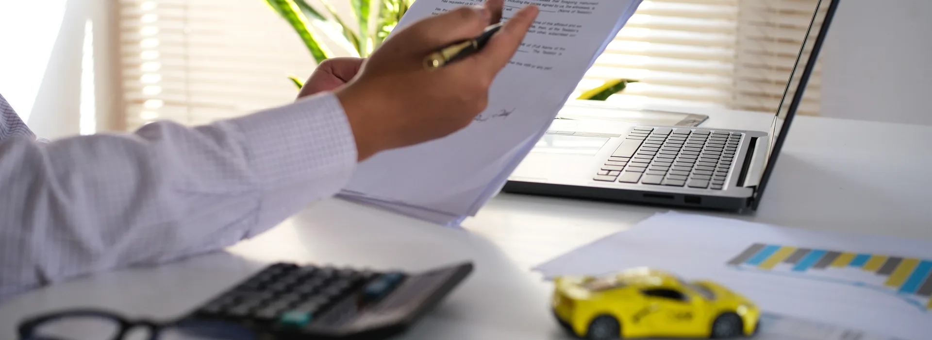 Car title paperwork being reviewed beside a toy car