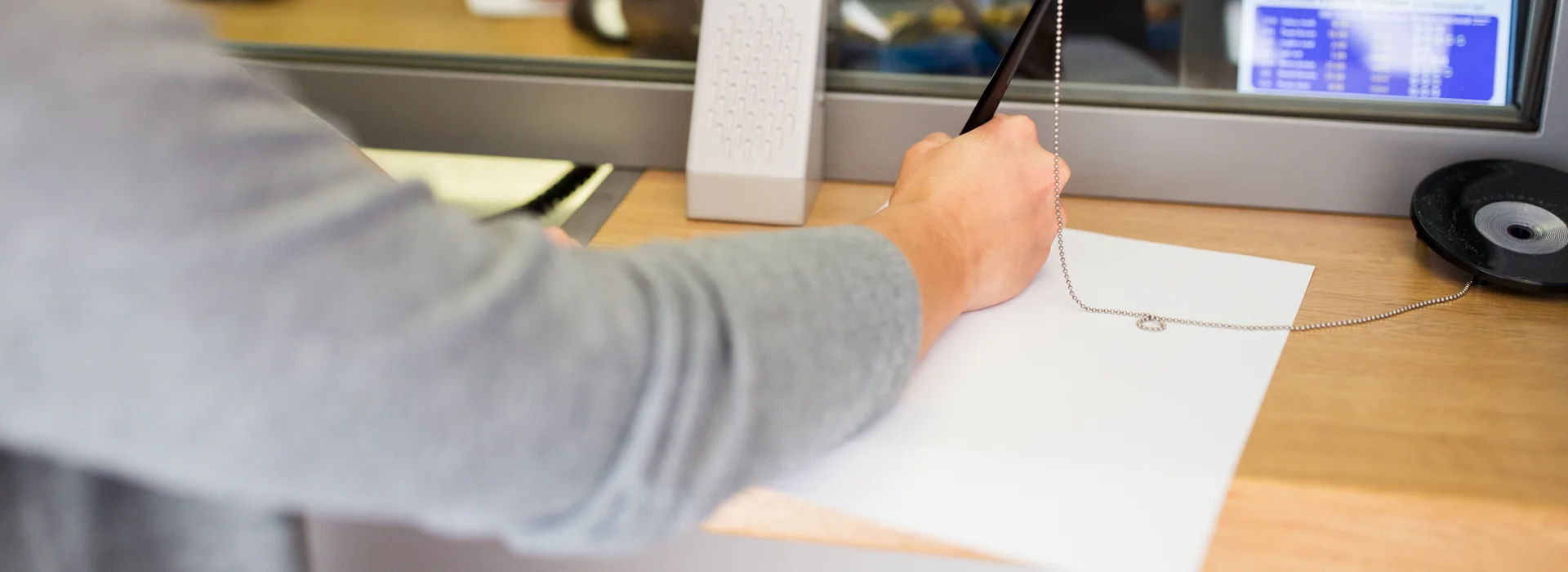 Customer completing a money order form at a bank counter
