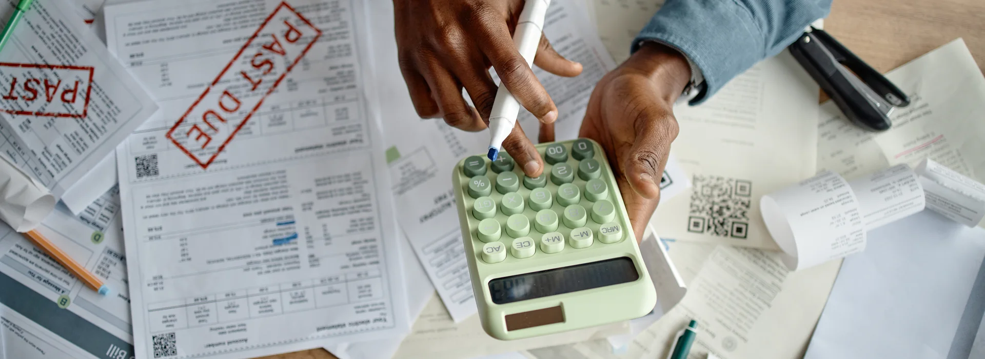 Man organizing bills and past-due notices into a repayment plan