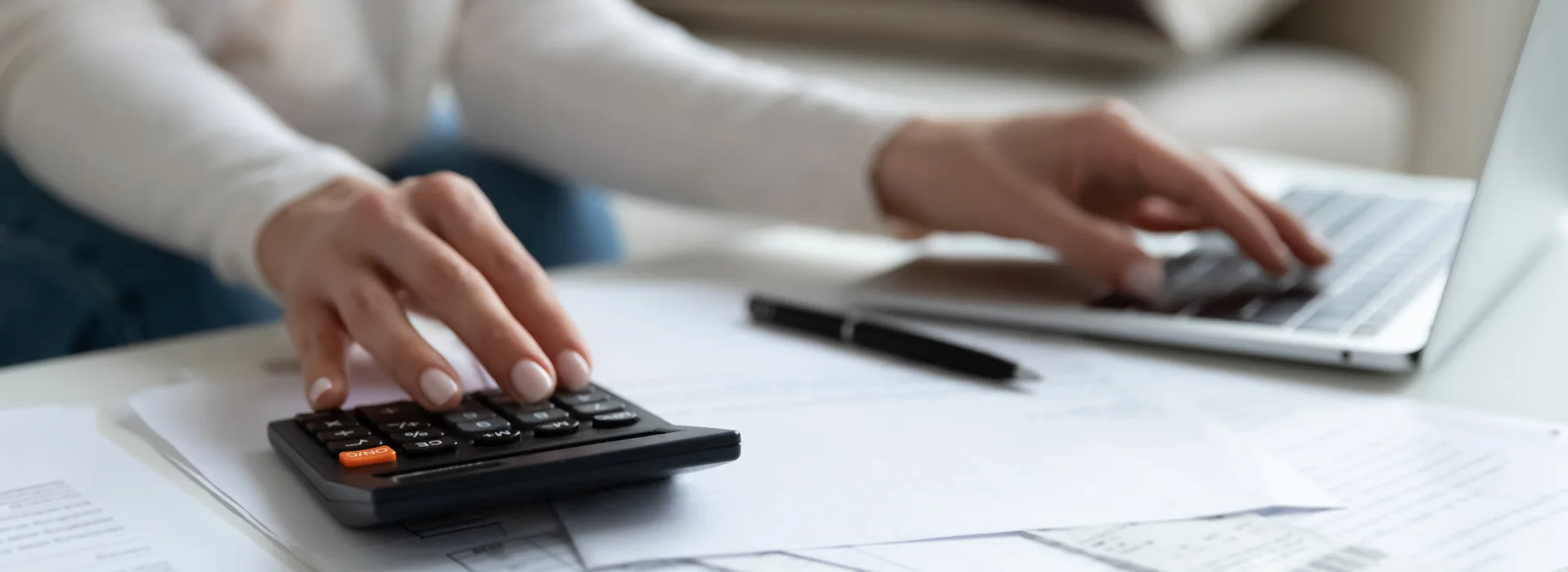 Woman comparing debt repayment options with bills and a calculator