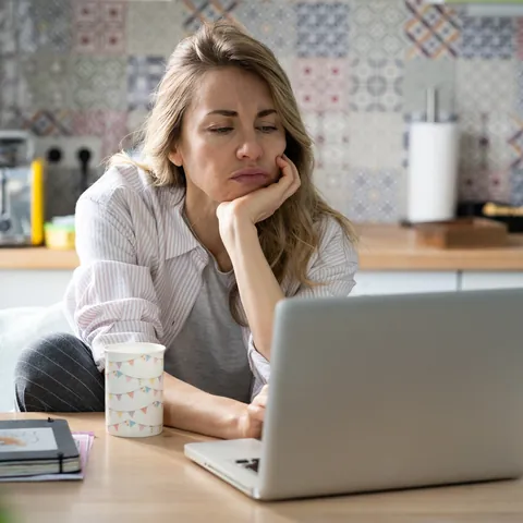 Woman reviewing job listings on a laptop at home