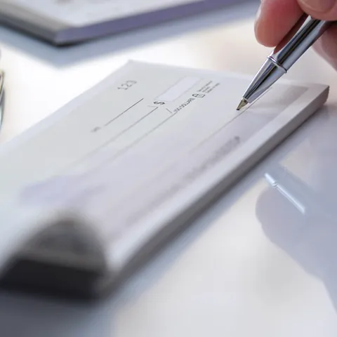 Businessman hand hold pen fill a banque cheque document