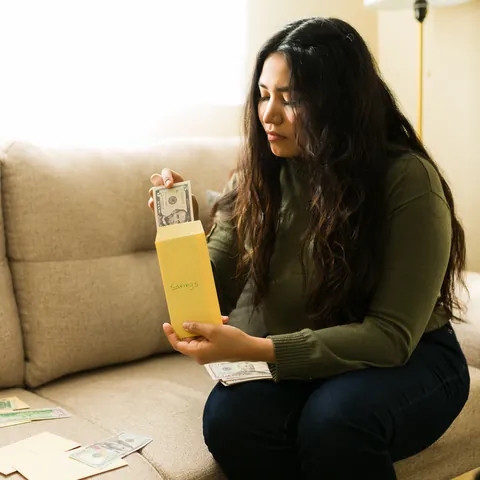Woman organizing cash into budget envelopes